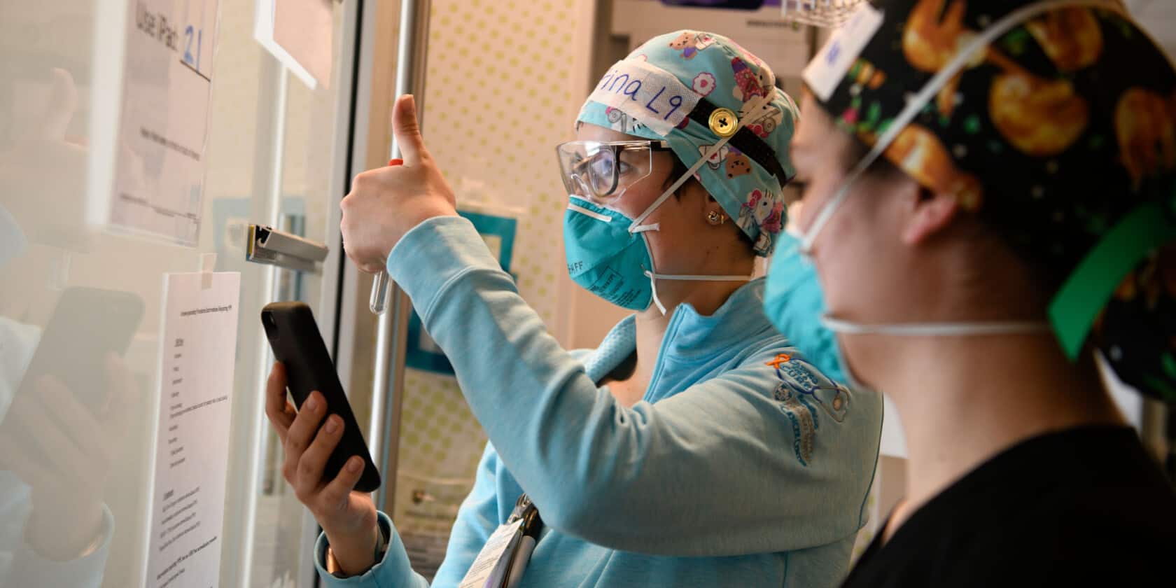 Doctor on phone with thumbs up.